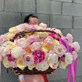 Large basket of pink and cream roses held by a person