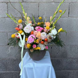Colorful mixed flower arrangement in a round vase with tall stems