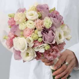 Handheld bouquet of blush, lavender, and white roses with pink ruffled blooms