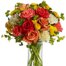 Mixed roses and mums in a clear glass vase