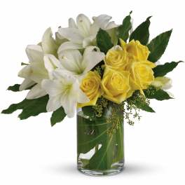 White lilies and yellow roses in a glass vase