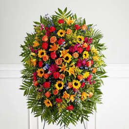 Large standing floral spray with sunflowers, roses, lilies, and carnations