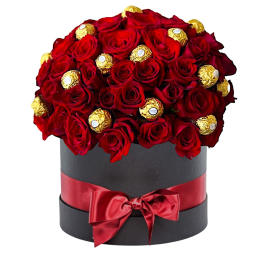 Red roses and gold-wrapped chocolates in a black hat box with a red ribbon