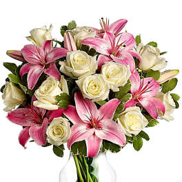 Pink lilies and white roses arranged in a clear glass vase