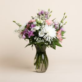 Mixed pink, white, and purple bouquet in a glass vase