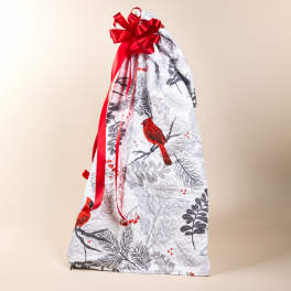 Gift bag wrapped in bird-patterned fabric with a red ribbon bow
