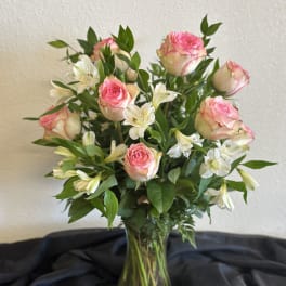 Pink roses and white alstroemeria in a clear glass vase