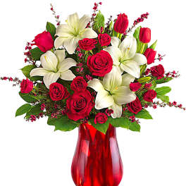 Red roses and white lilies in a red glass vase