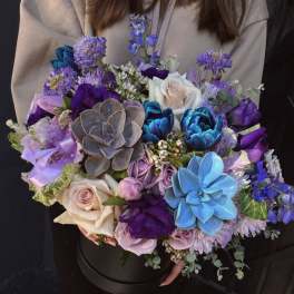 Large bouquet of purple, blue, and white flowers in a black box