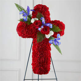 Red floral cross on a stand with roses and purple accents