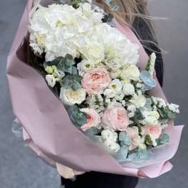 Large bouquet of white and blush flowers wrapped in pink paper