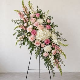 Pink and white floral spray on a black stand