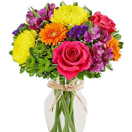 Mixed bouquet of roses, gerbera daisies, and alstroemeria in a glass vase