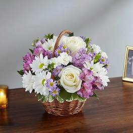 Basket arrangement of white roses, daisies, and purple flowers