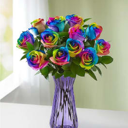 Bouquet of rainbow-colored roses in a purple glass vase