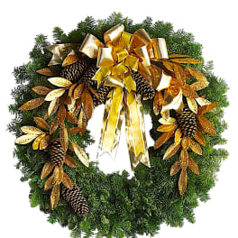 Evergreen wreath with gold ribbon, pinecones, and glittered leaves