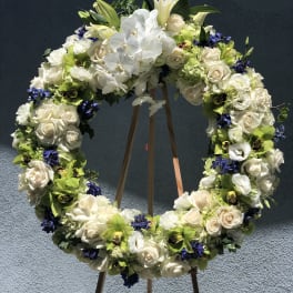 Large floral wreath on a wooden stand with white roses and orchids