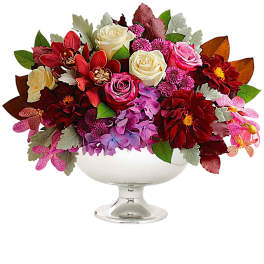 Mixed bouquet of roses and orchids in a white pedestal bowl