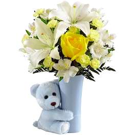 White lilies and yellow roses in a blue vase with a teddy bear