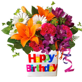 Bright mixed bouquet in a birthday vase with ribbons