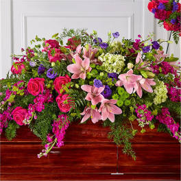Large pink and purple floral casket spray with lilies and roses
