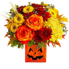 Orange and yellow floral arrangement in a jack-o'-lantern vase