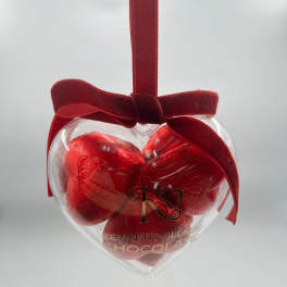 Heart-shaped chocolate gift box with a red ribbon bow