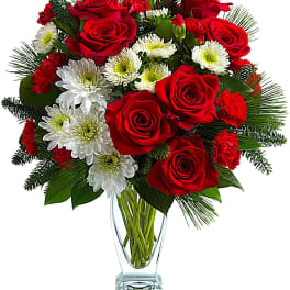 Red roses and white daisies in a clear glass vase