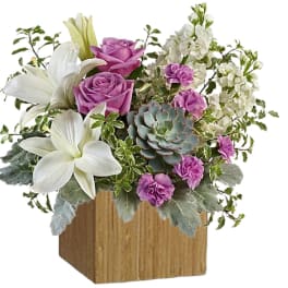 Pink roses and white lilies arranged in a wooden cube vase