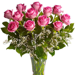 Pink roses arranged in a clear glass vase with white filler flowers