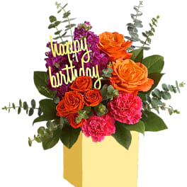 Birthday flower arrangement in a yellow box with roses and carnations