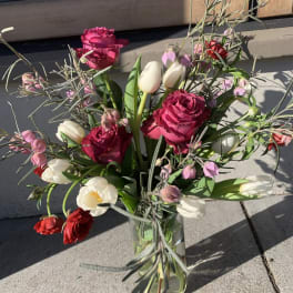 Mixed bouquet of pink roses and white tulips in a glass vase