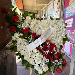 Heart-shaped standing wreath of red and white roses on an easel