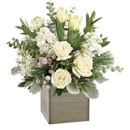 White roses and pale tulips in a wooden cube vase