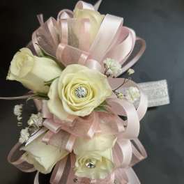 Cream roses with pink ribbon loops and small white filler flowers