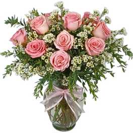 Pink roses in a glass vase with white filler flowers