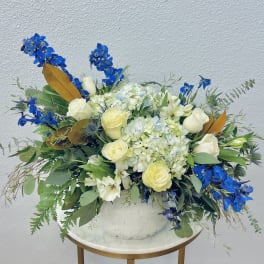 Blue and white floral arrangement in a white vase