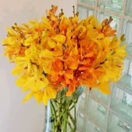 Yellow and orange flowers in a clear glass vase
