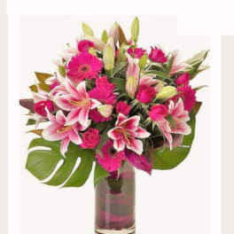 Pink lilies and gerbera daisies in a glass vase