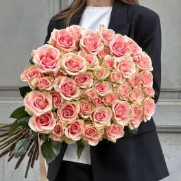 Large bouquet of pink roses held by a person in a black suit