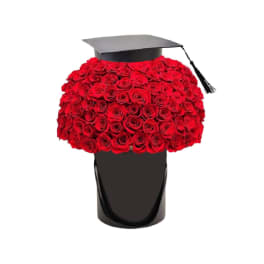 Red rose arrangement in a black hatbox with a graduation cap topper