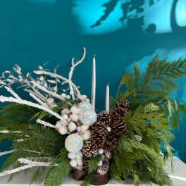 Winter centerpiece with pinecones, white accents, and silver candles