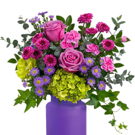 Pink and purple flower arrangement in a purple vase