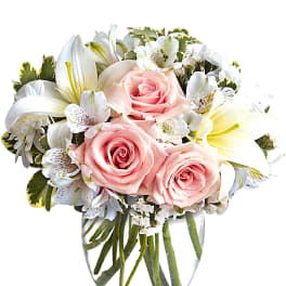 Pink roses and white lilies in a clear glass vase