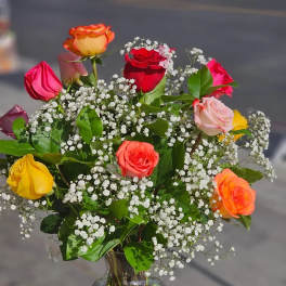Mixed roses in a clear glass vase with baby's breath