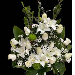 White lilies and roses in a white vase with green accents