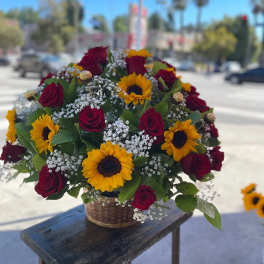 Basket arrangement of red roses and yellow sunflowers