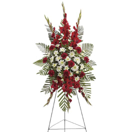 Standing funeral spray with red and white flowers on an easel