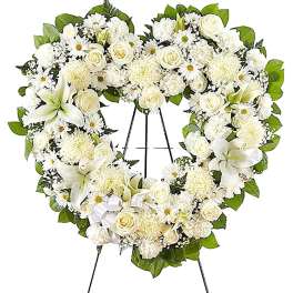 Heart-shaped white floral wreath on a standing easel