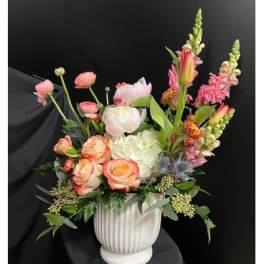 Mixed pink and white floral arrangement in a white vase